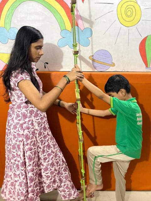 A therapist guiding a boy on the climbing ladder
