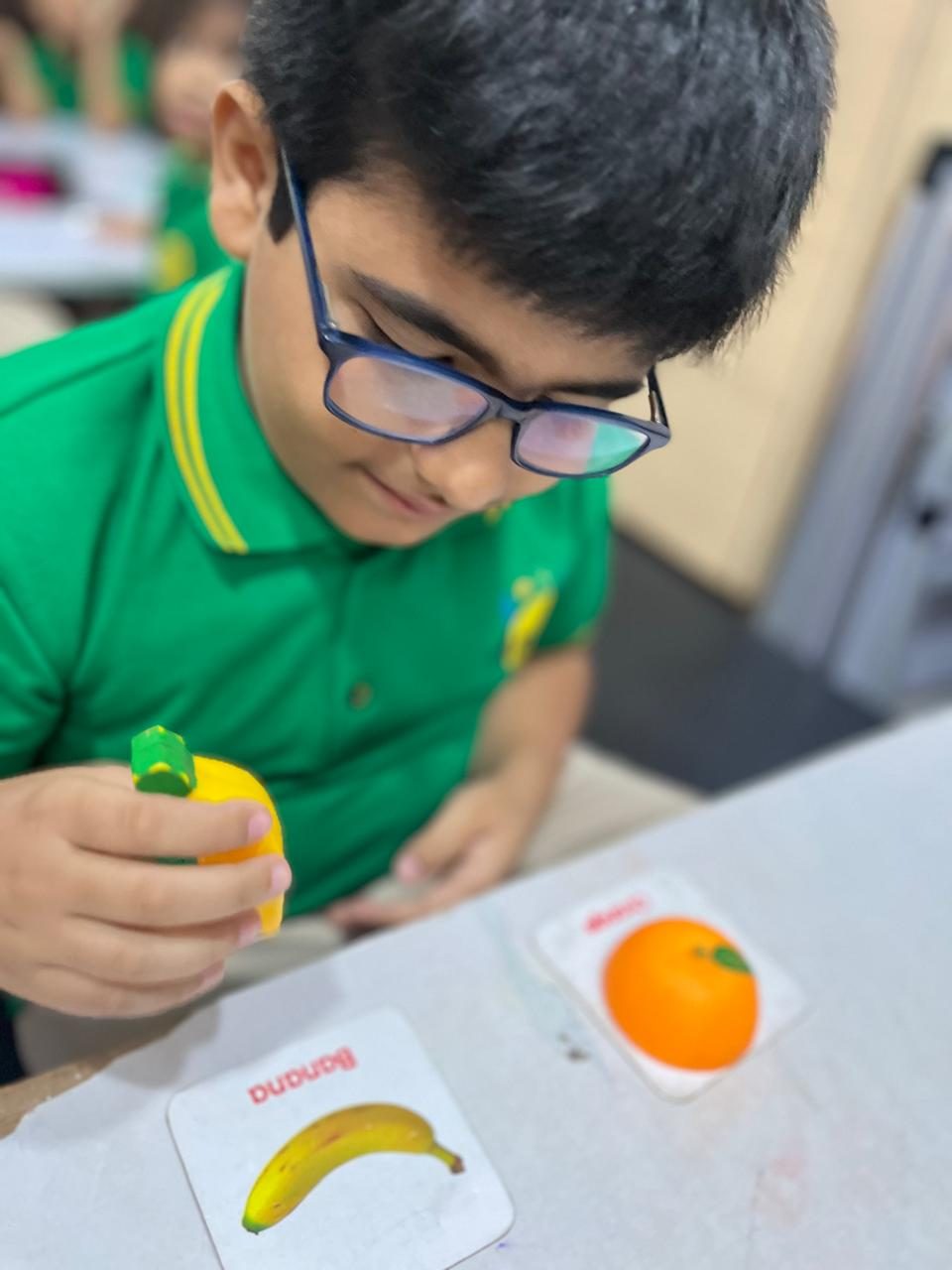 A boy matching fruit to picture cards at Anvi